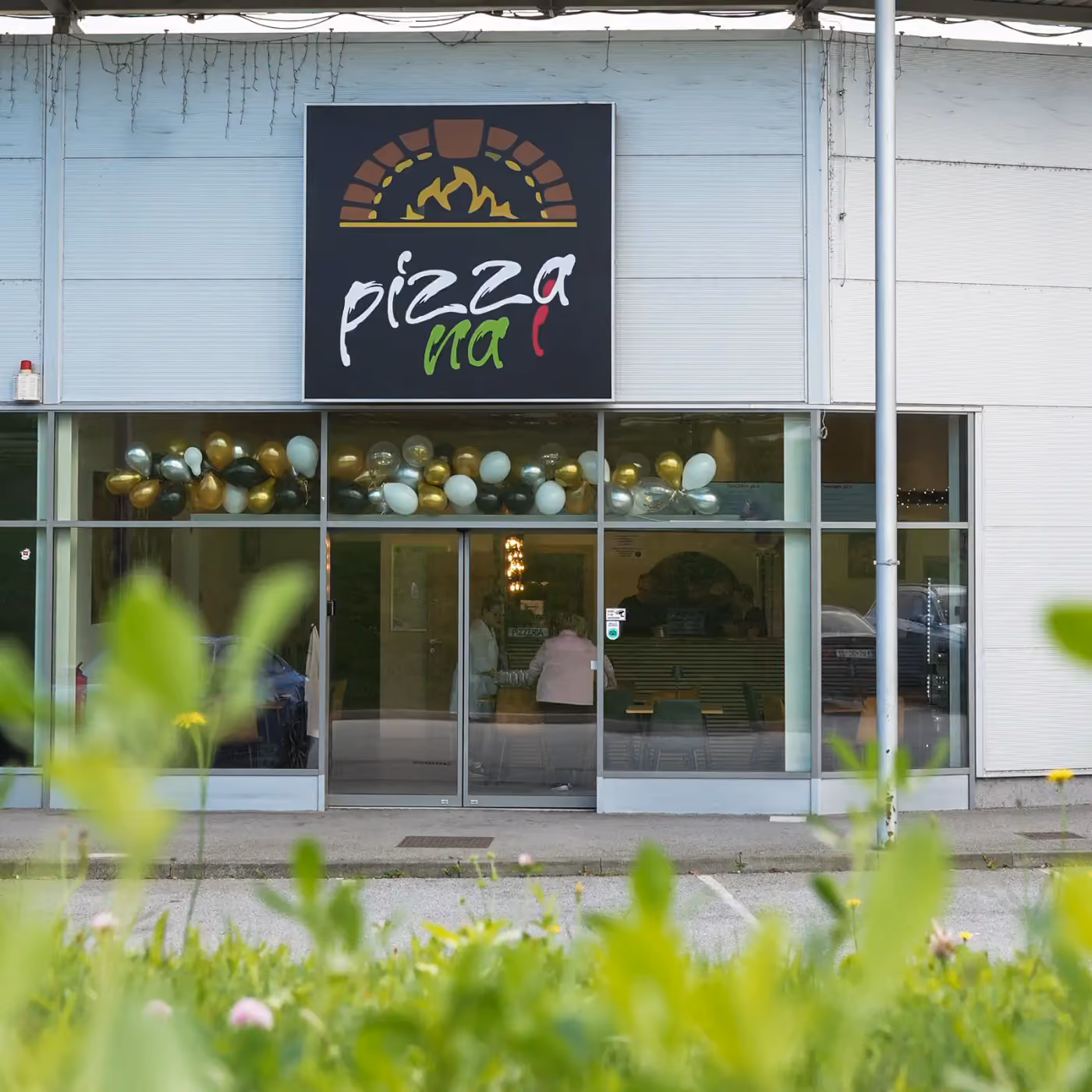 Zunanjost lokala v Lenartu z napisom Pizza na i
